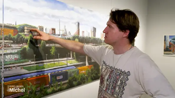 Maler Ralf Schwinge steht vor einem seiner Gemälde.