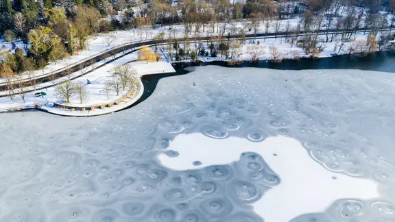 Hannover: Eine Eisfläche mit Mustern bedeckt den Maschsee an der Löwenbastion (Luftaufnahme mit Drohne) | dap-Bildfunk, Julian Stratenschulte Hannover: Eine Eisfläche mit Mustern bedeckt den Maschsee an der Löwenbastion (Luftaufnahme mit Drohne)