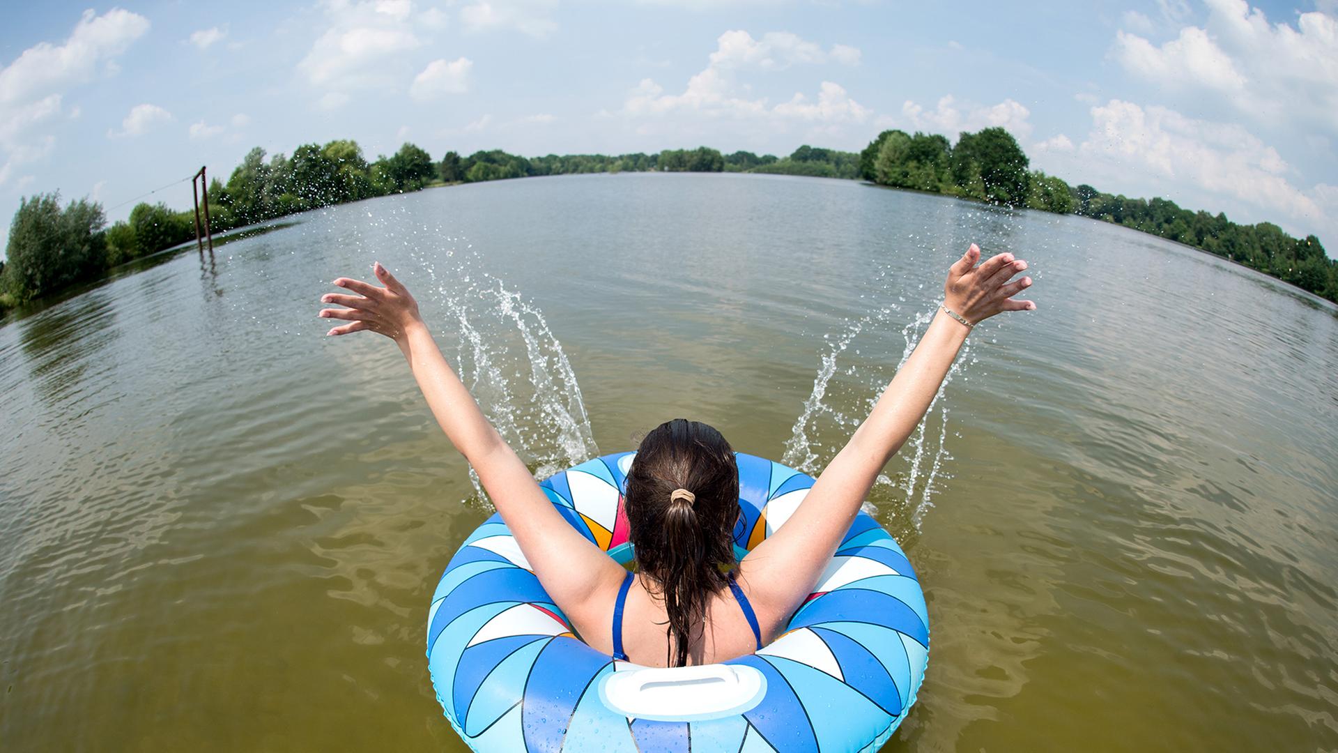 Uetze: Ein junge Frau badet mit einem Schwimmreifen im Irenensee | picture alliance, Hauke-Christian Dittrich