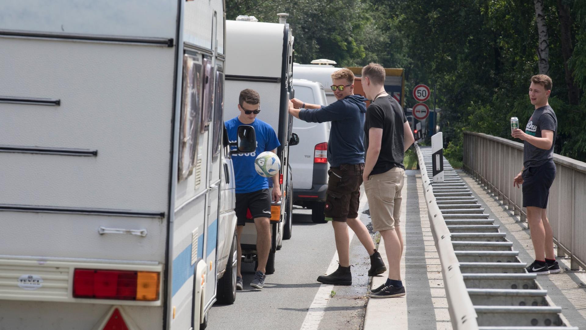 mehrere junge Männer neben ihrem Fahrzeug im Stau auf der Anreise zum Hurricane Festival 2017 in Scheeßel | picture alliance / Jörg Sarbach/dpa | Jörg Sarbach, Jörg Sarbach