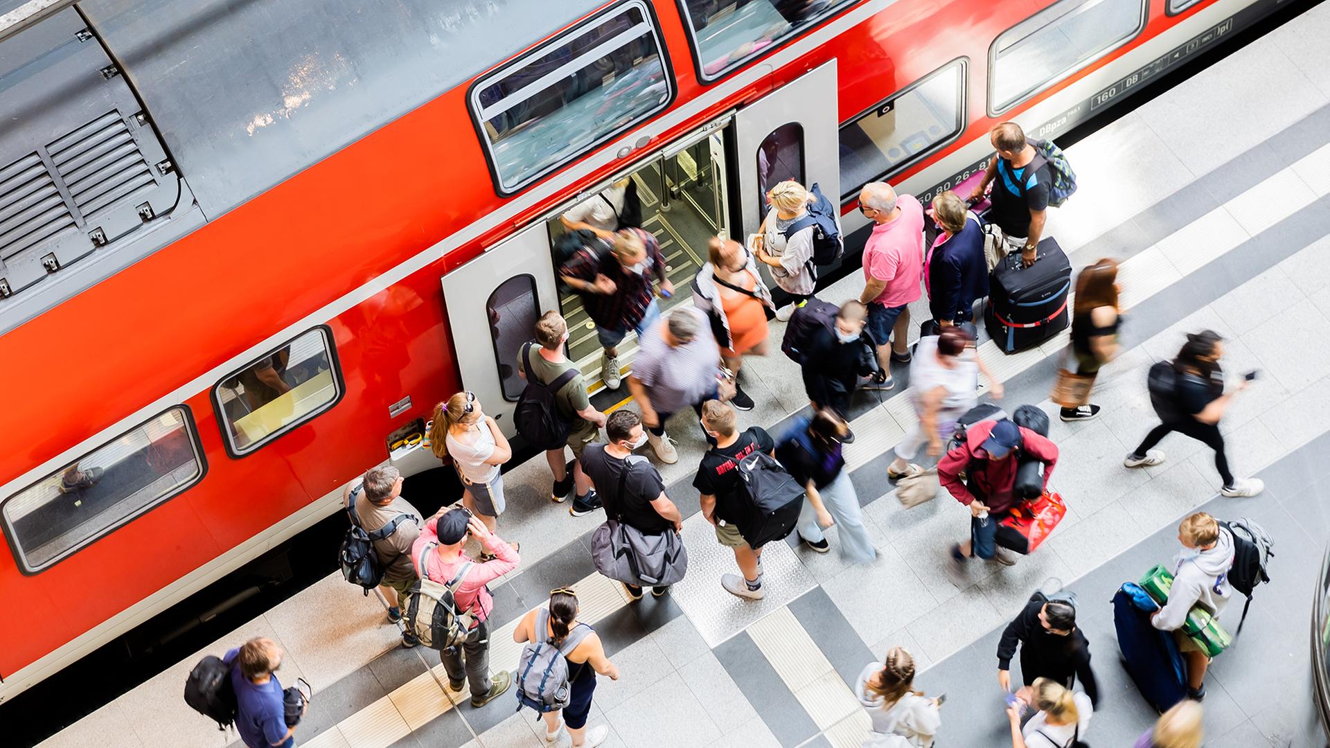 Menschen steigen aus einer Regionalbahn aus. | picture alliance/dpa/Christoph Soeder, Christoph Soeder