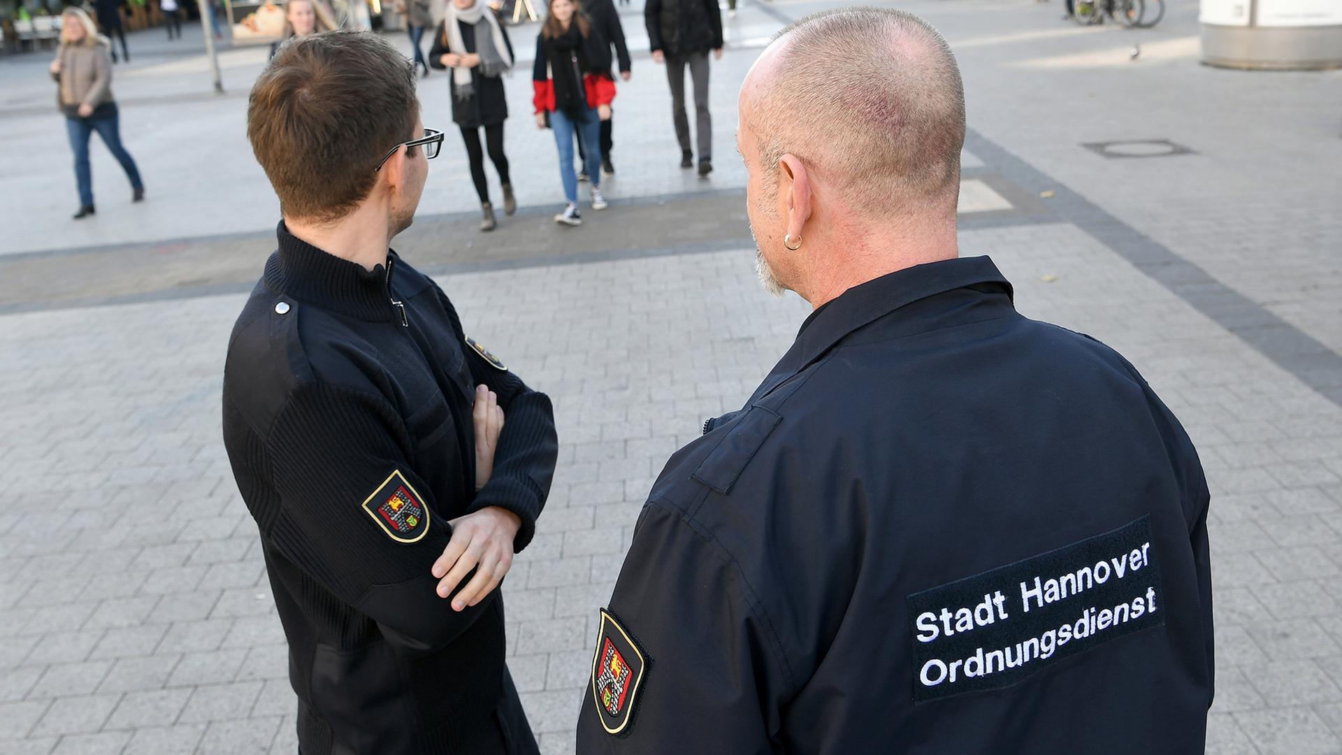 Zwei Mitarbeiter des städtischen Ordnungsdienstes stehen in der Fußgängerzone in der Innenstadt Hannovers. | dpa-Bildfunk, Holger Hollemann