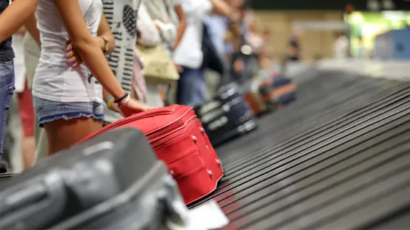 Kommt der Koffer nicht am Urlaubsort an, haben Reisende Anrecht darauf, sich die nötigsten Dinge auf Kosten der Airline zu kaufen. | fotolia, Brian Jackson Fluggäste warten am Flughafen am Kofferlaufband.