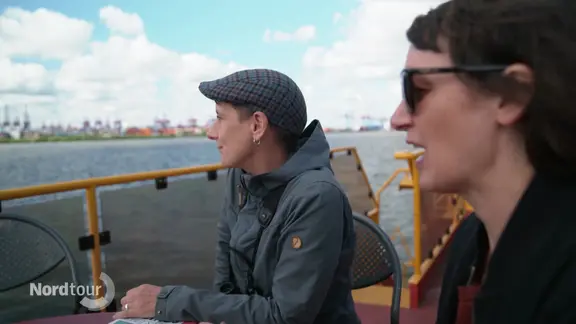 Zwei Fraue an Deck einer Hamburger Fähre, die über die Elbe fährt.