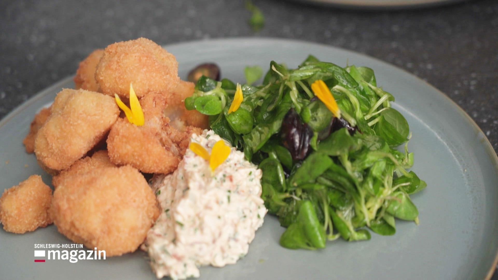 Frittierter Blumenkohl auf einem Teller angerichtet mit Trauben-Feldsalat.  | Screenshot