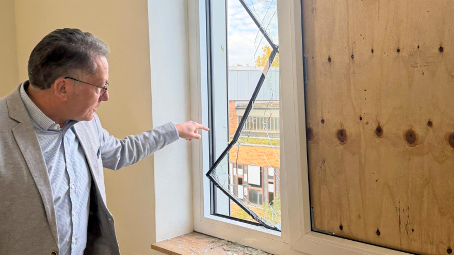 Schulleiter Robert Baberske vom  Gymnasium Großburgwedel deutet auf ein zerstörtes Fenster. | Stadt Großburgwedel