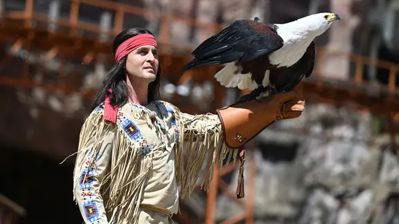 Alexander Klaws als Winnetou steht mit einem Adler auf dem Arm in der Arena auf dem Kalkberg