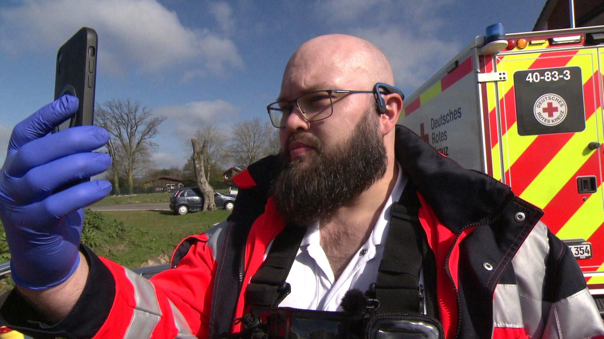 Telemedizin für den Notfall proben: Ein Sanitäter bei einer Übung mit einem Handy in der Hand. | NDR
