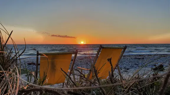 Strandkörbe bei Sonnenuntergang am Flügger Strand auf Fehmarn.