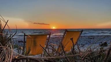 Strandkörbe bei Sonnenuntergang am Flügger Strand auf Fehmarn.