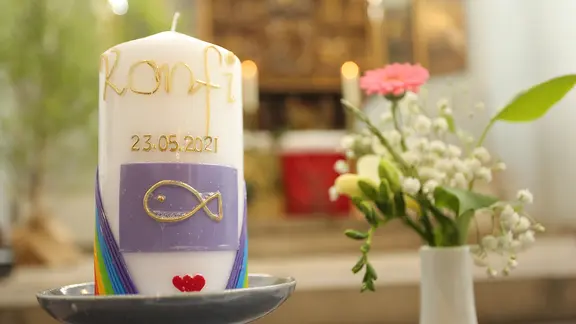 Blumenschmuck und eine Konfirmationskerze stehen in der St. Sylvestrikirche.