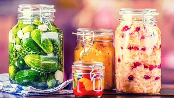 Eingekochte Gurken, Paprika, Kürbis und Kohl in Bügelgläsern.