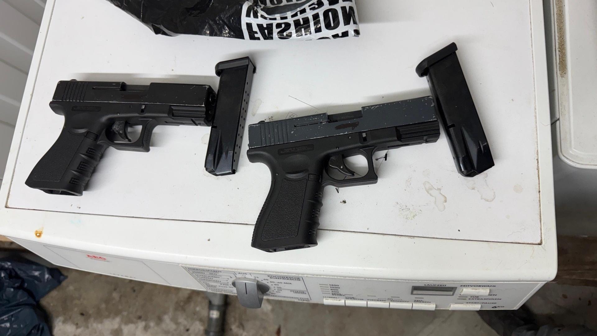 Zwei schwarze Pistolen liegen auf einer Waschmaschine. | Bundespolizeidirektion Hannover