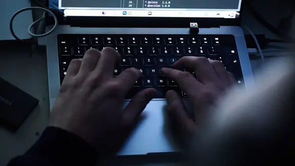 Hände tippen auf einer Computer-Tastatur.
