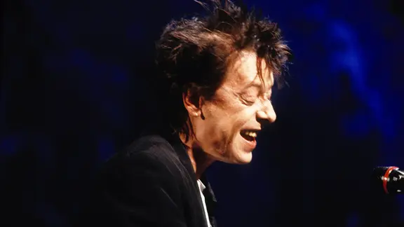 Rio Reiser im Profil mit unordentlicher Frisur live in den 90ern.