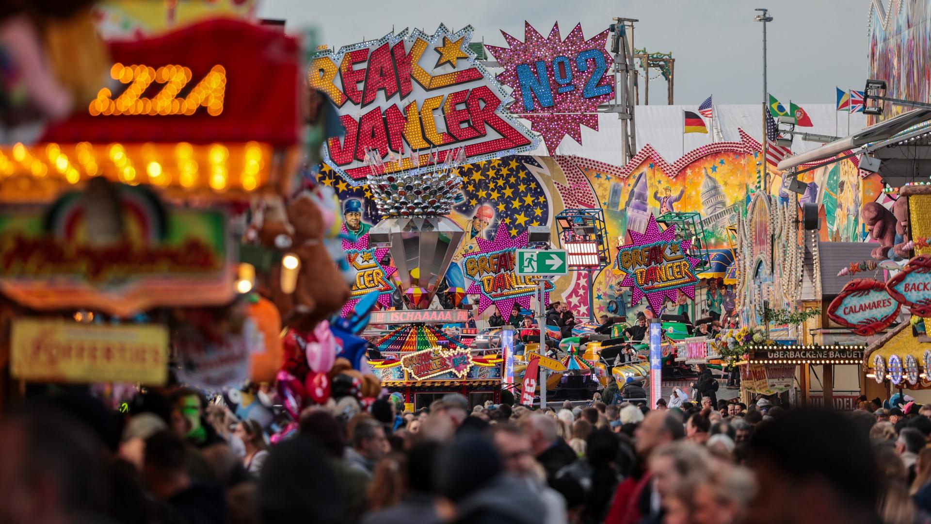 Menschen gehen auf dem Bremer Freimarkt zwischen Buden und Fahrgeschäfte. | picture alliance/dpa, Focke Strangmann