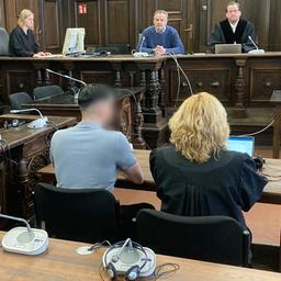 Der Angeklagte in einem Prozess um tödliche Schüsse in einer Shisha-Bar sitzt im Gerichtssaal im Hamburger Strafjustizgebäude neben seiner Verteidigerin.