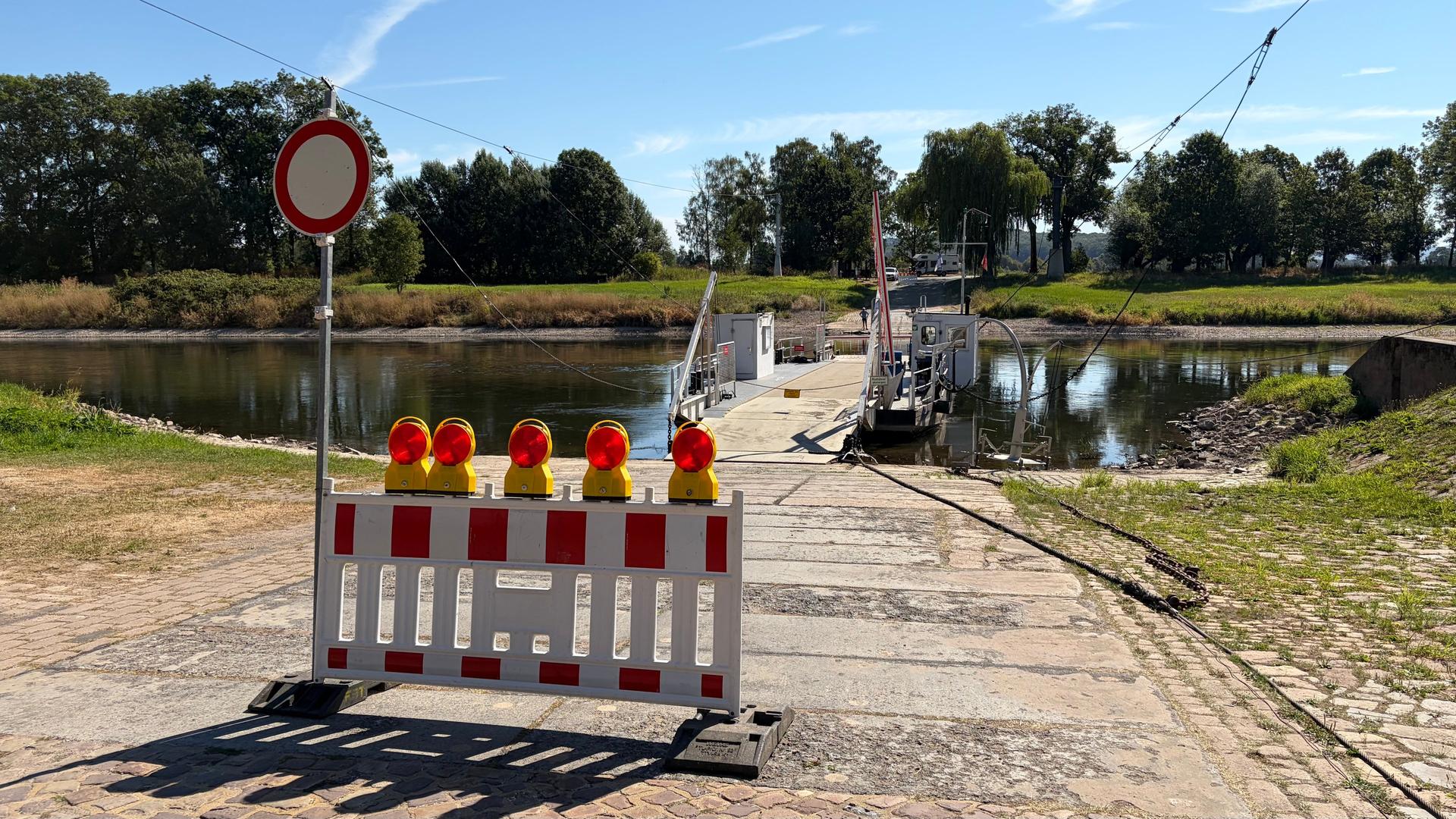 Vor einer Fähre auf einem Fluss mit Niedrigwasser steht eine Absperrung. | NDR, Wolfgang Kurtz