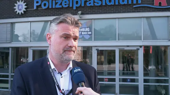 Jan Reinecke, Landesvorsitzender des Bund Deutscher Kriminalbeamter (BDK) in Hamburg, gibt dem NDR ein Interview vor dem Polizeipräsidium. (Archivfoto)
