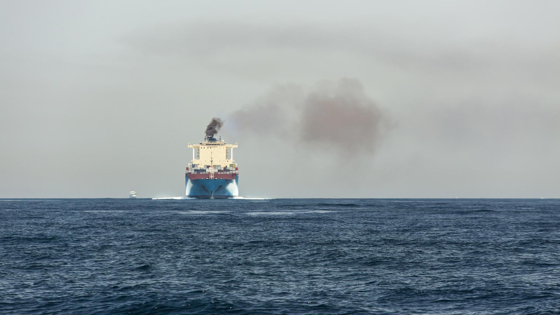 Ein Schiff auf dem Meer stößt schwarzen Rauch aus. | picture alliance / Sebastian Kanzler