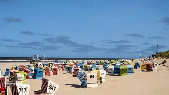 Strandkörbe am Strand von Langeoog bei strahlend blauem Himmel.
