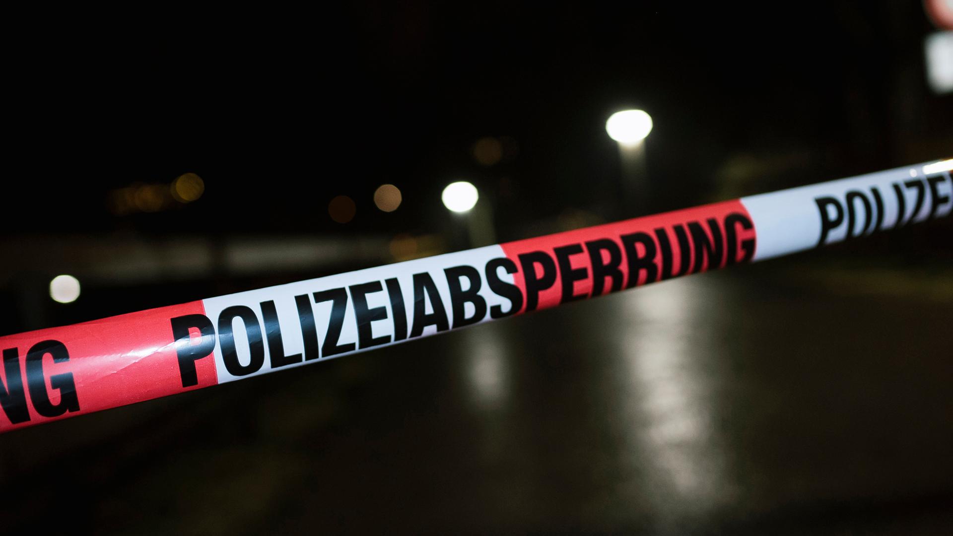 Ein Absperrband der Polizei vor dunklem Hintergrund bewegt sich im Wind. | NDR, Julius Matuschik
