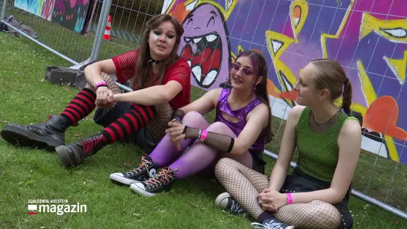 Die drei jungen Lübeckerinnen der Band Quiet Girl sitzen auf dem Rasen und geben ein Interview auf der Kieler Woche.