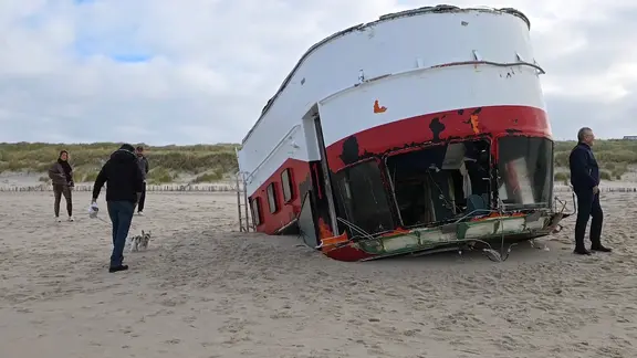 Ein umgestürztes Lotsenboot liegt an einem Strand an der Nordsee. | Nachrichten ohne Unterbrechung Ein umgestürztes Lotsenboot liegt an einem Strand an der Nordsee.