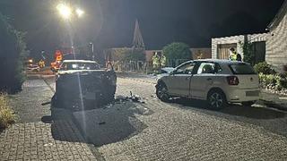 Nach einem Unfall stehen zwei beschädigte Fahrzeuge in einer Straße.