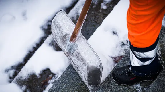 Ein Winterdienst-Mitarbeiter befreit am Morgen eine Treppe in Hannover von Schnee. | dpa, Moritz Frankenberg Ein Winterdienst-Mitarbeiter befreit am Morgen eine Treppe in Hannover von Schnee.