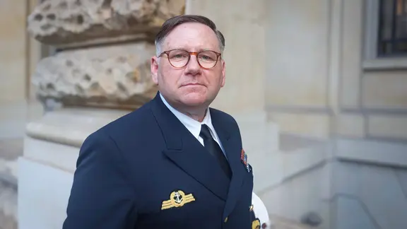 Kapitän Kurt Leonards steht vor einer Deutschlandflagge