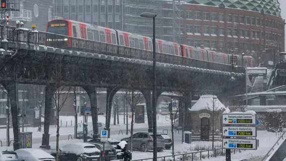 Eine U-Bahn fährt in Hamburg bei Schneefall am Baumwall entlang. | picture alliance / HOCH ZWEI | Juergen Tap Eine U-Bahn fährt in Hamburg bei Schneefall am Baumwall entlang.