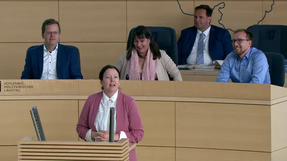 Eine Abgeordnete steht am Rednerpult im Kieler Landtag bei einer Debatte.