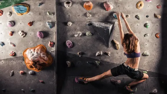 Eine Frau klettern an einer Kletterwand. | Colourbox Eine Frau klettern an einer Kletterwand.