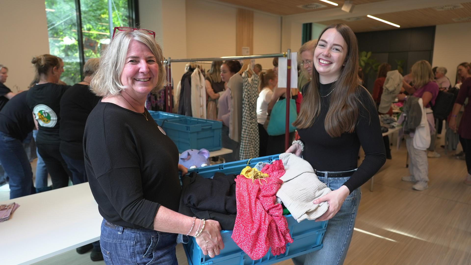 Paula (l.) und Tanja (r.) Probst durchstöbern Kleidung. | NDR