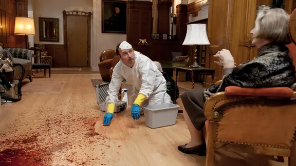 Tatortreiniger Heiko Schotte (Bjarne Mädel) erklärt der Hausbesitzerin (Christine Schorn) mit welchen Spezialmitteln er das Blut wegputzt.