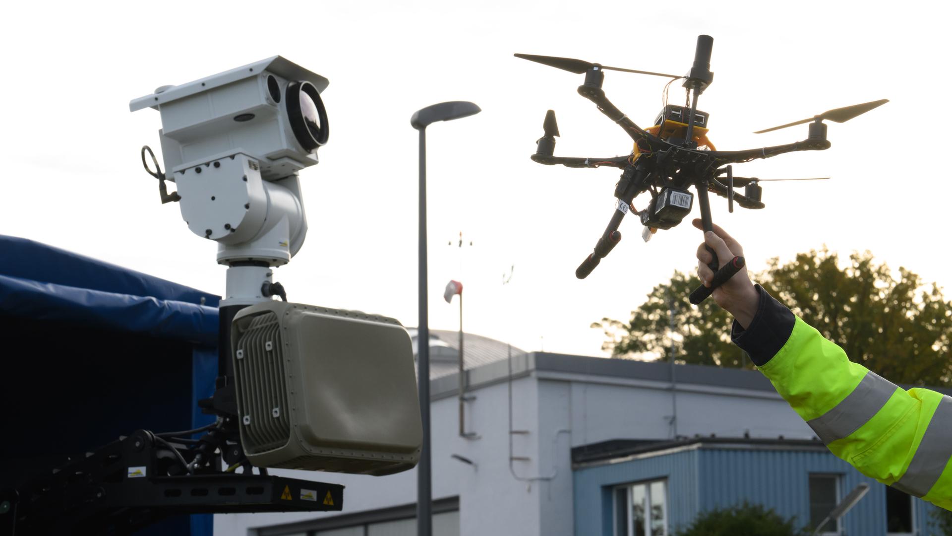 Ein DLR-Mitarbeiter hält eine Drohne auf dem Gelände des Deutsches Zentrums für Luft- und Raumfahrt in Braunschweig. | picture alliance / dpa | Julian Stratenschulte