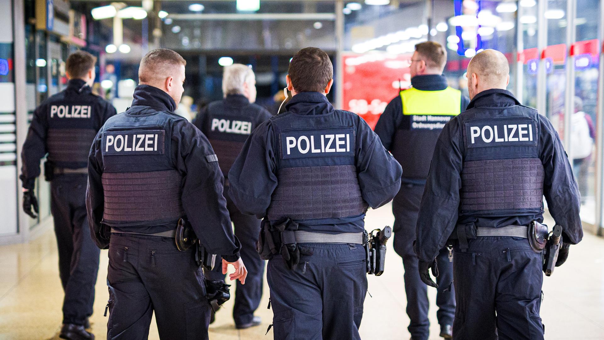 Einsatzkräfte von Bundespolizei und Ordnungsdienst gehen durch den Hauptbahnhof Hannover. | picture alliance/dpa, Moritz Frankenberg