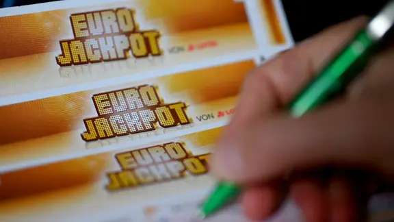 Ein Mann füllt einen Eurojackpot-Lotterieschein aus.