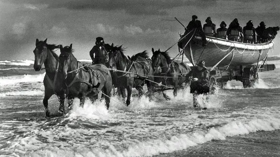 Eine historische Fotografie zeigt ein Ruderrettungsboot auf einem Ablaufwagen.