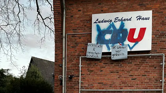 An dem Backsteingebäude der CDU-Parteizentrale wurden die Buchstaben C und U mit Farbe übersprüht. Daran hängen Schilder mit der Aufschrift: Unchristlich und menschenfeindlich.