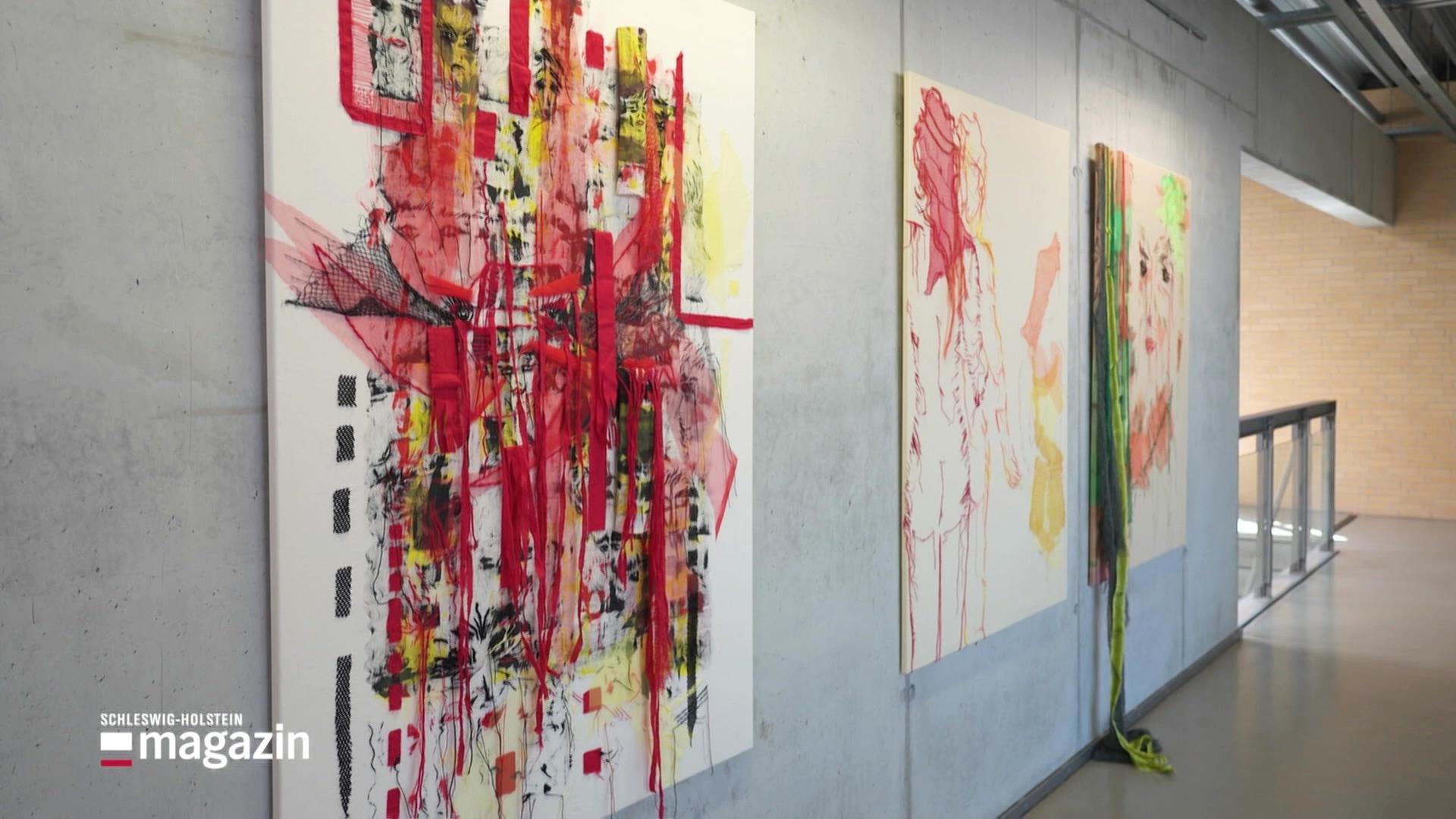 Drei bunte Bilder aus Textilien hängen in einer Ausstellung. | Screenshot