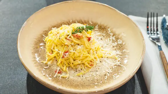 Spaghetti alla carbonara auf einem Teller angerichtet.