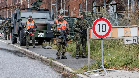 Reservisten der Bundeswehr stehen vor einem Einsatzfahrzeug im Hamburger Hafen.