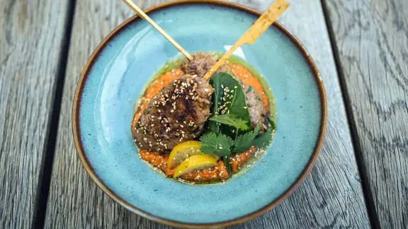 Lammhackspieße auf Paprika-Hummus serviert