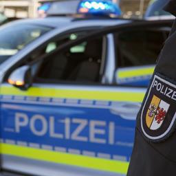 Ein Polizist steht vor einem Streifenwagen aus Mecklenburg-Vorpommern.