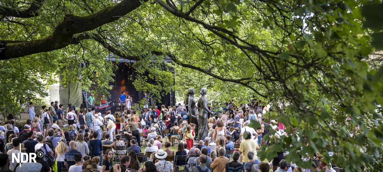Publikum vor einer Bühne in einem Park während der Fête de la musique | picture alliance/KEYSTONE | MARTIAL TREZZINI Publikum vor einer Bühne in einem Park während der Fête de la musique