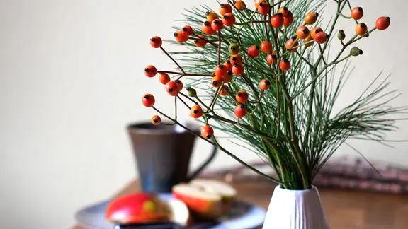 Weihnachtsdeko mit Beerenzweigen für die Vase