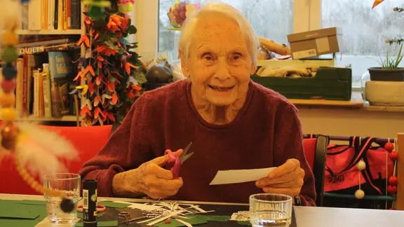 Annelotte Durner hat bei einer Bastelstunde eine Schere in der Hand.