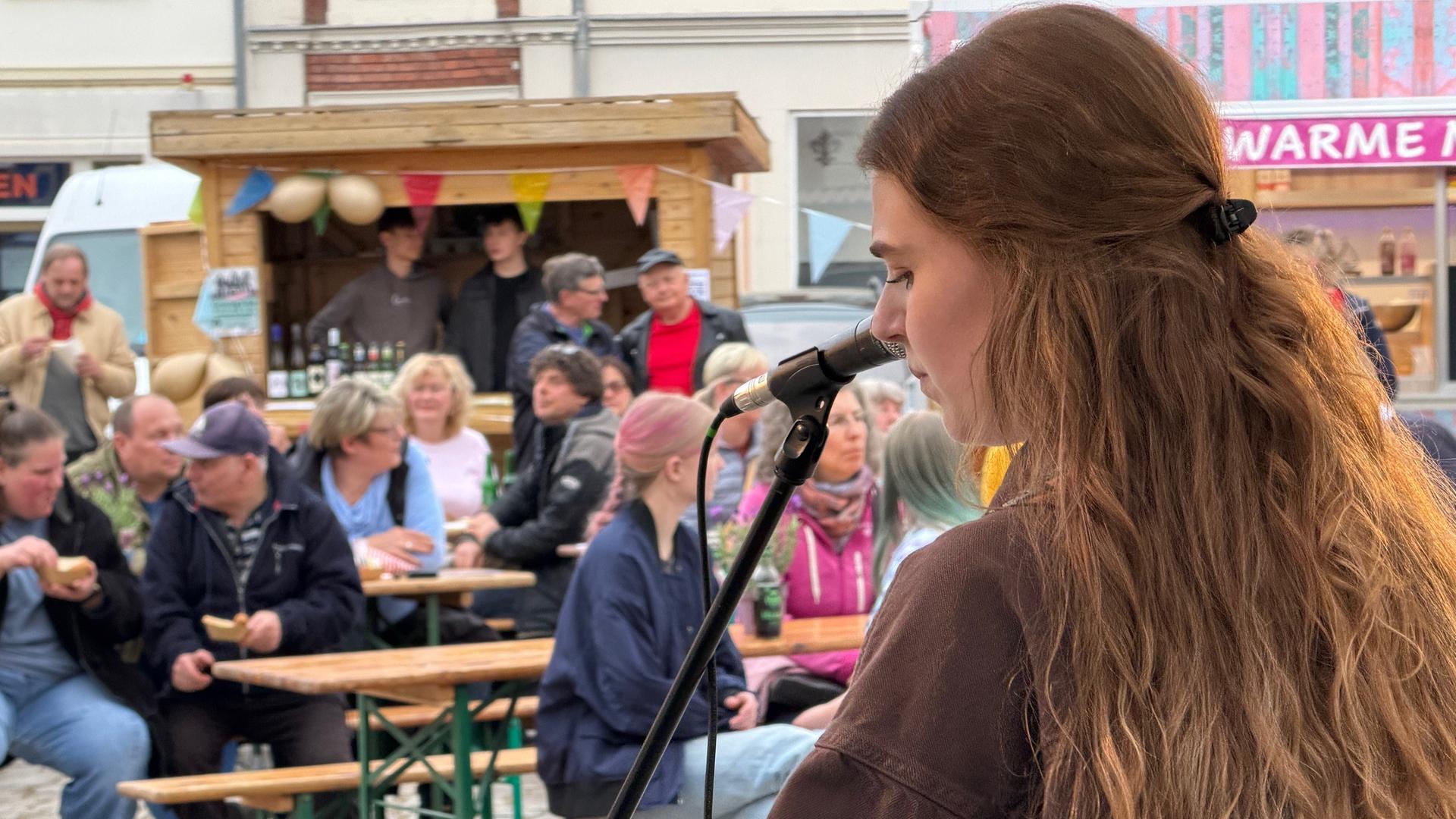 Eine Musikerin spielt auf einer Bühne Gitarre vor Publikum. | NDR, Jürn-Jakob Gericke